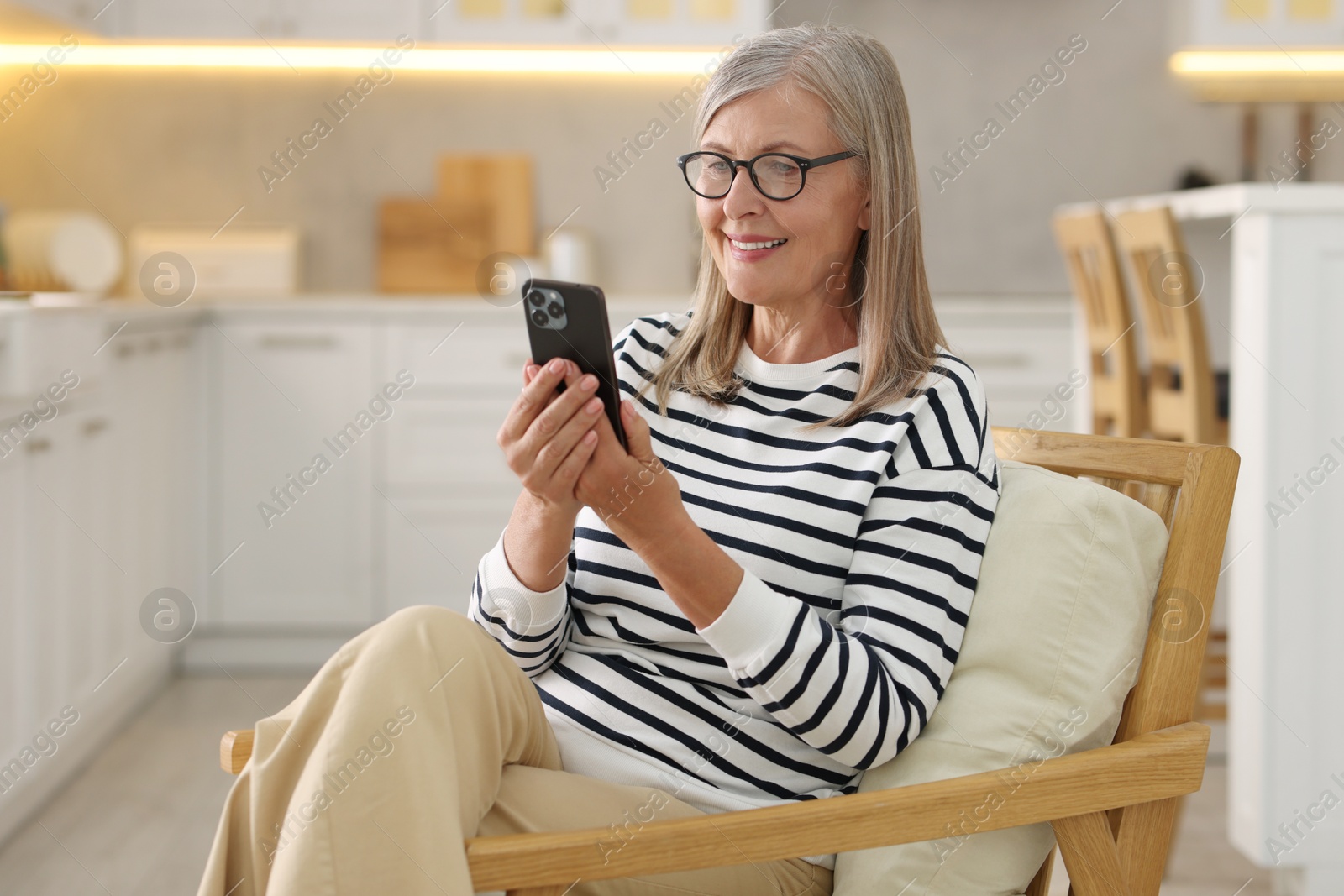 Photo of Senior woman using mobile phone at home