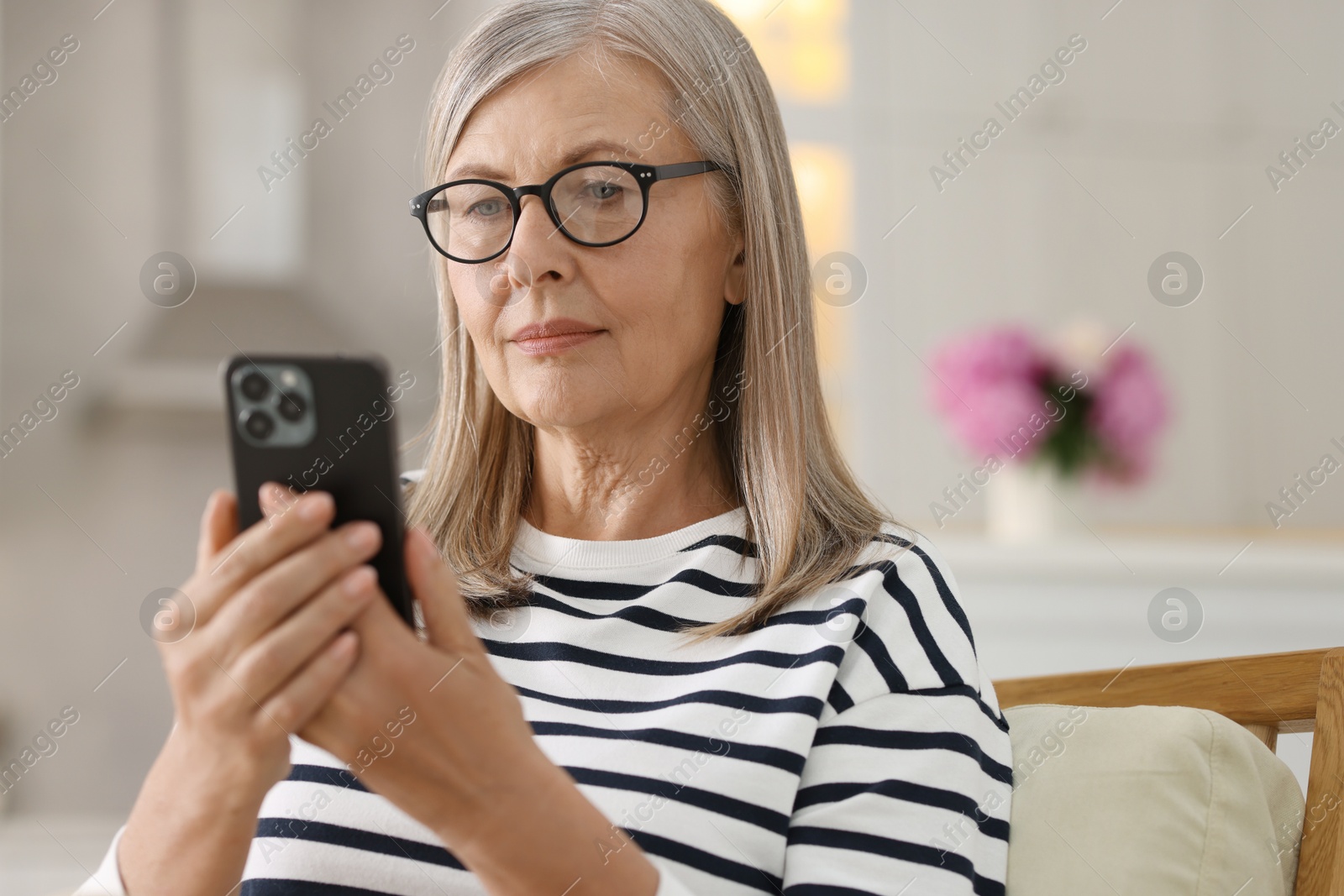 Photo of Senior woman using mobile phone at home