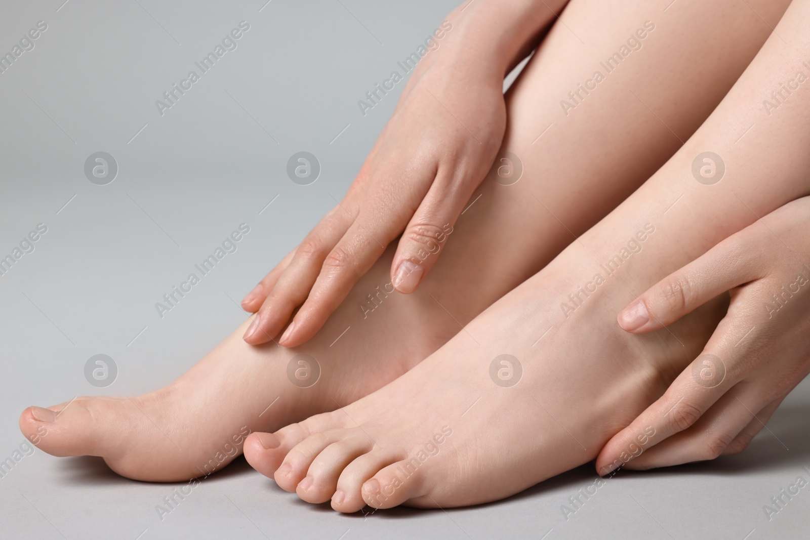 Photo of Closeup view of woman`s groomed feet after care procedure on grey background