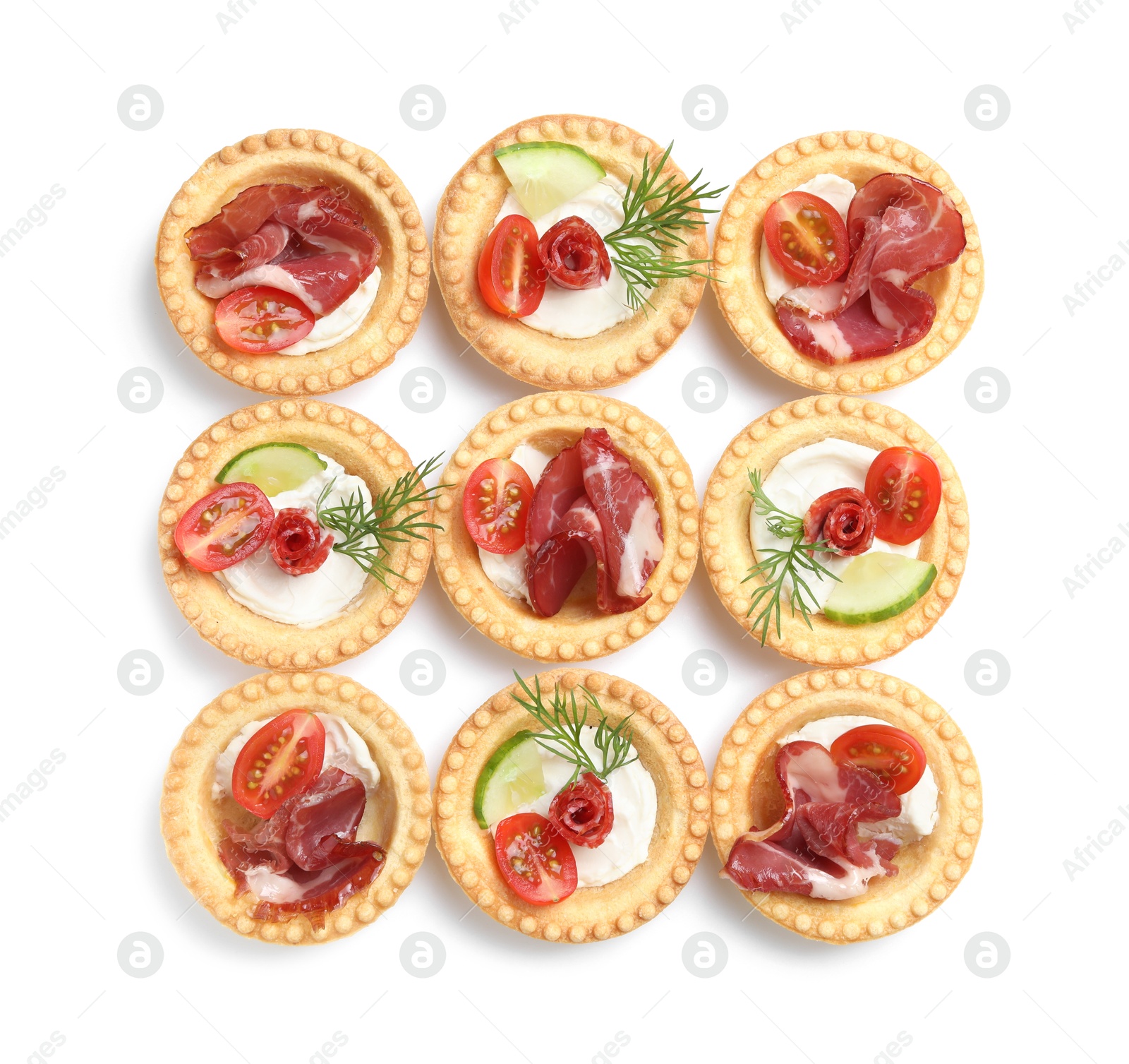 Photo of Delicious canapes with jamon, dry smoked sausages and vegetables isolated on white, top view