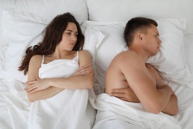 Offended couple after quarrel in bed, top view. Relationship problem