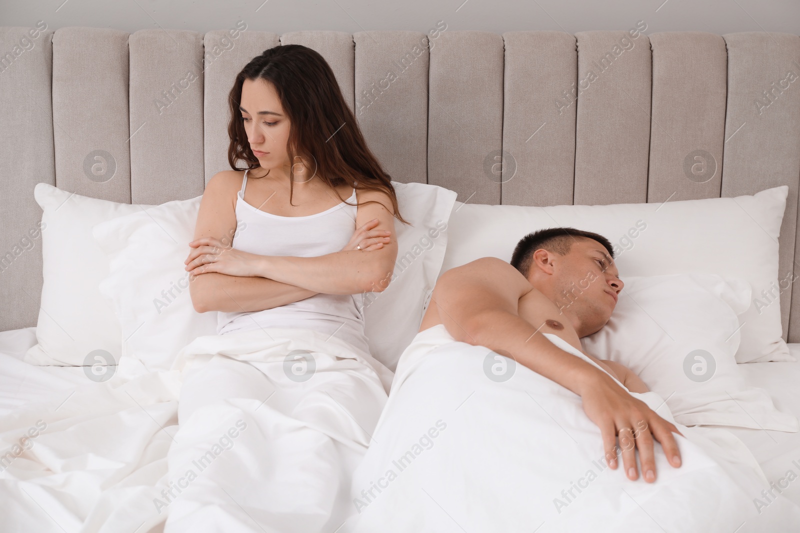 Photo of Offended couple ignoring each other in bed. Relationship problem