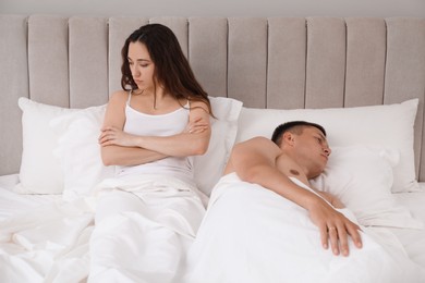 Offended couple ignoring each other in bed. Relationship problem