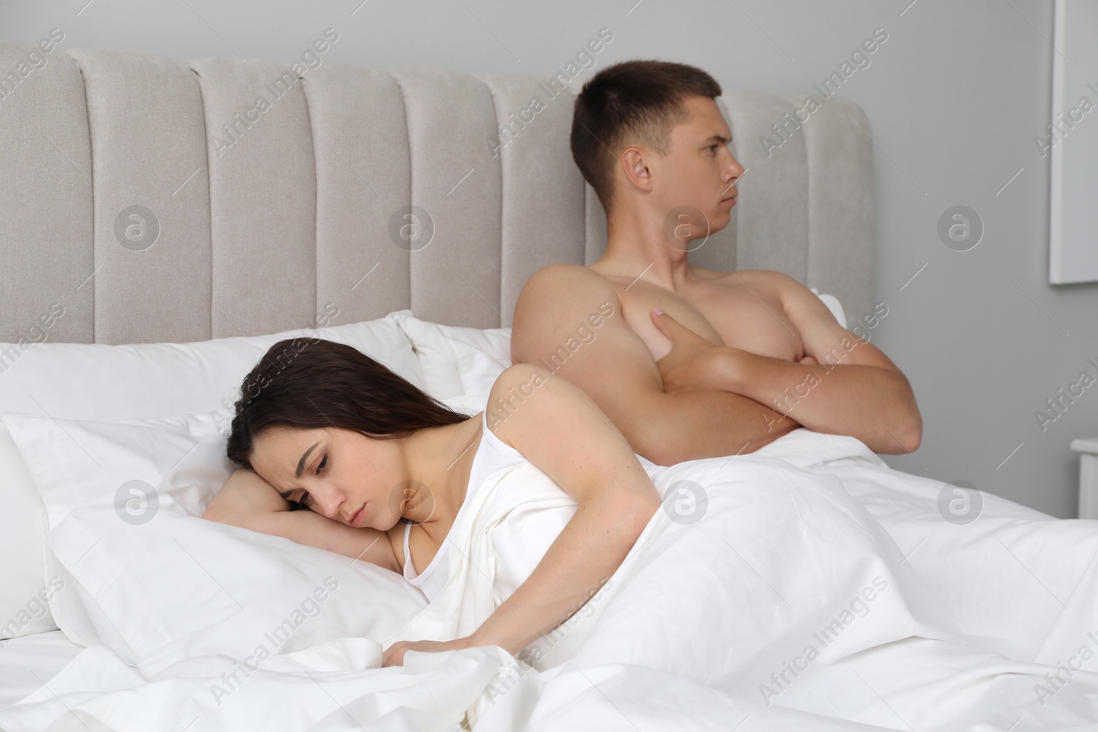 Photo of Offended couple ignoring each other in bed. Relationship problem