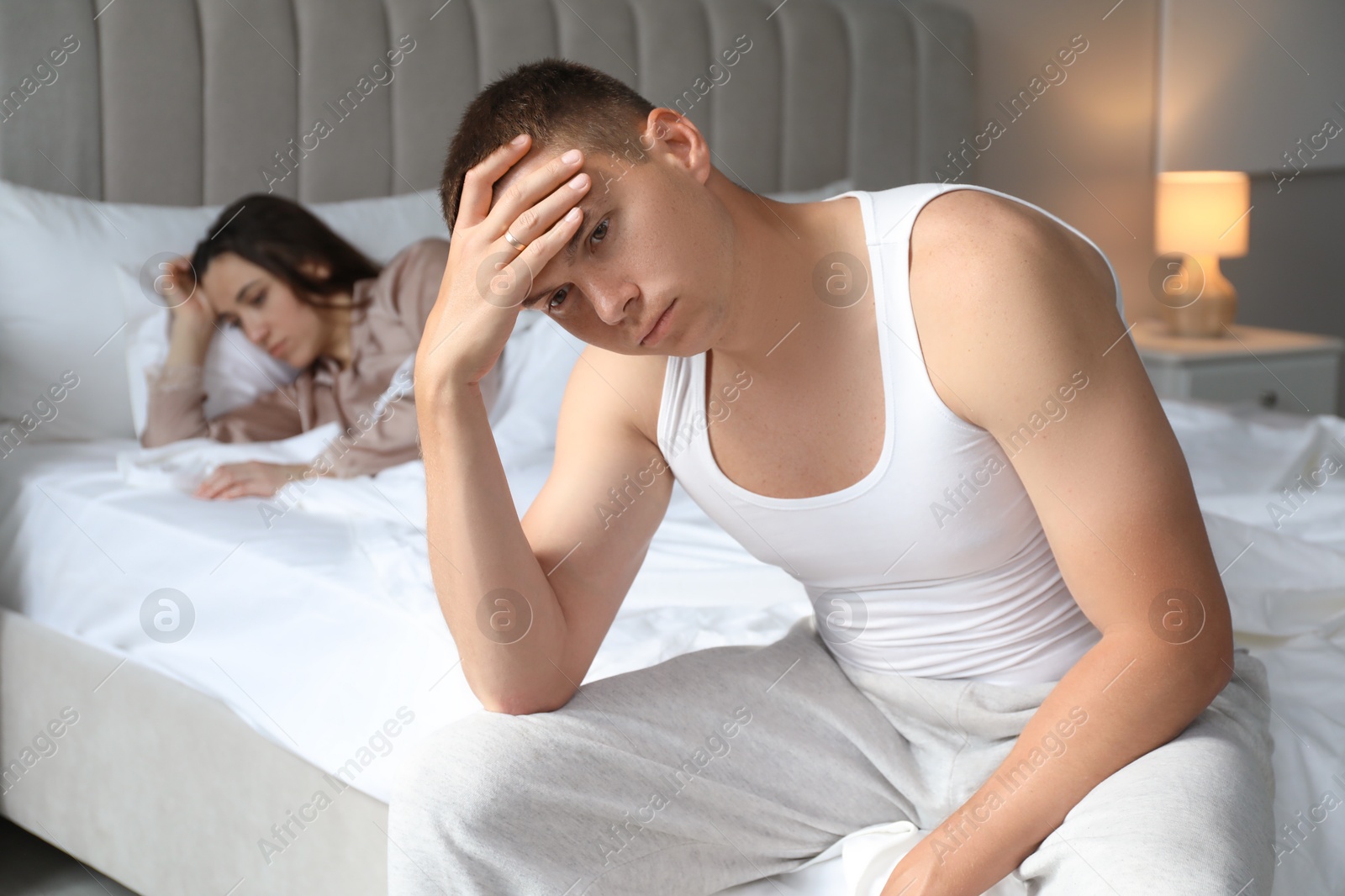 Photo of Offended couple ignoring each other in bedroom. Relationship problem