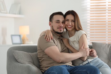 Cute couple hugging on sofa at home