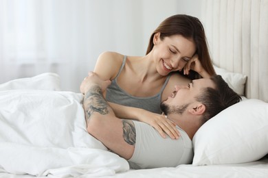 Happy couple enjoying each other in bed at home