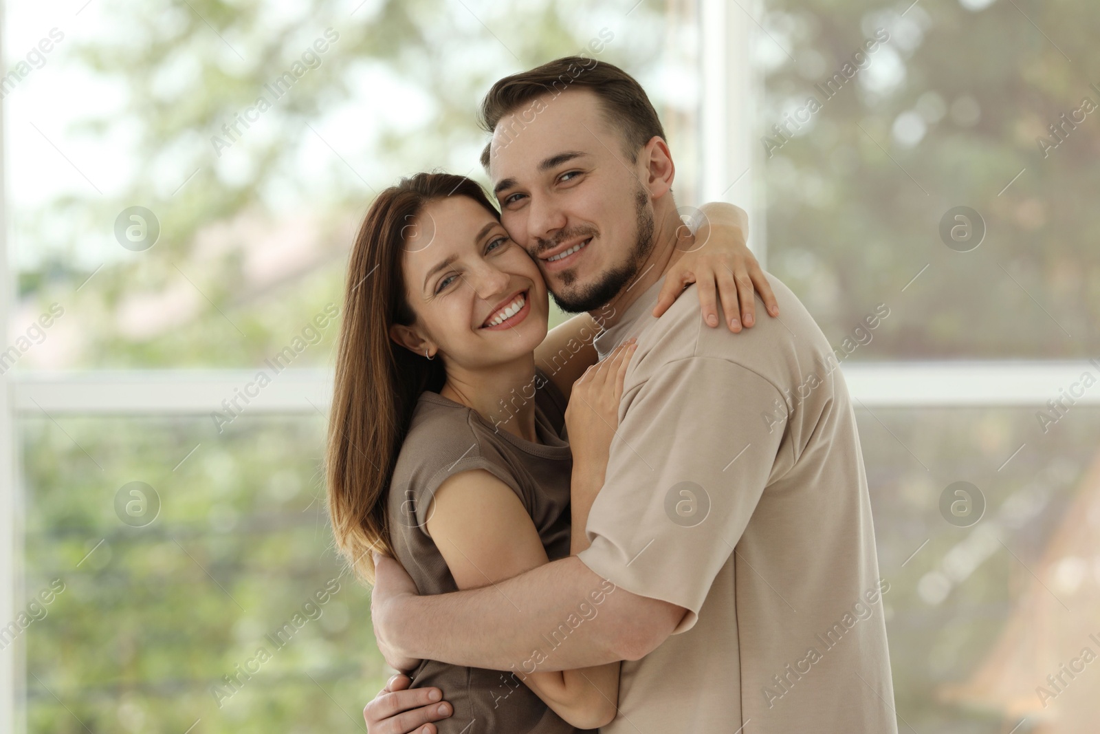 Photo of Portrait of happy couple hugging at home