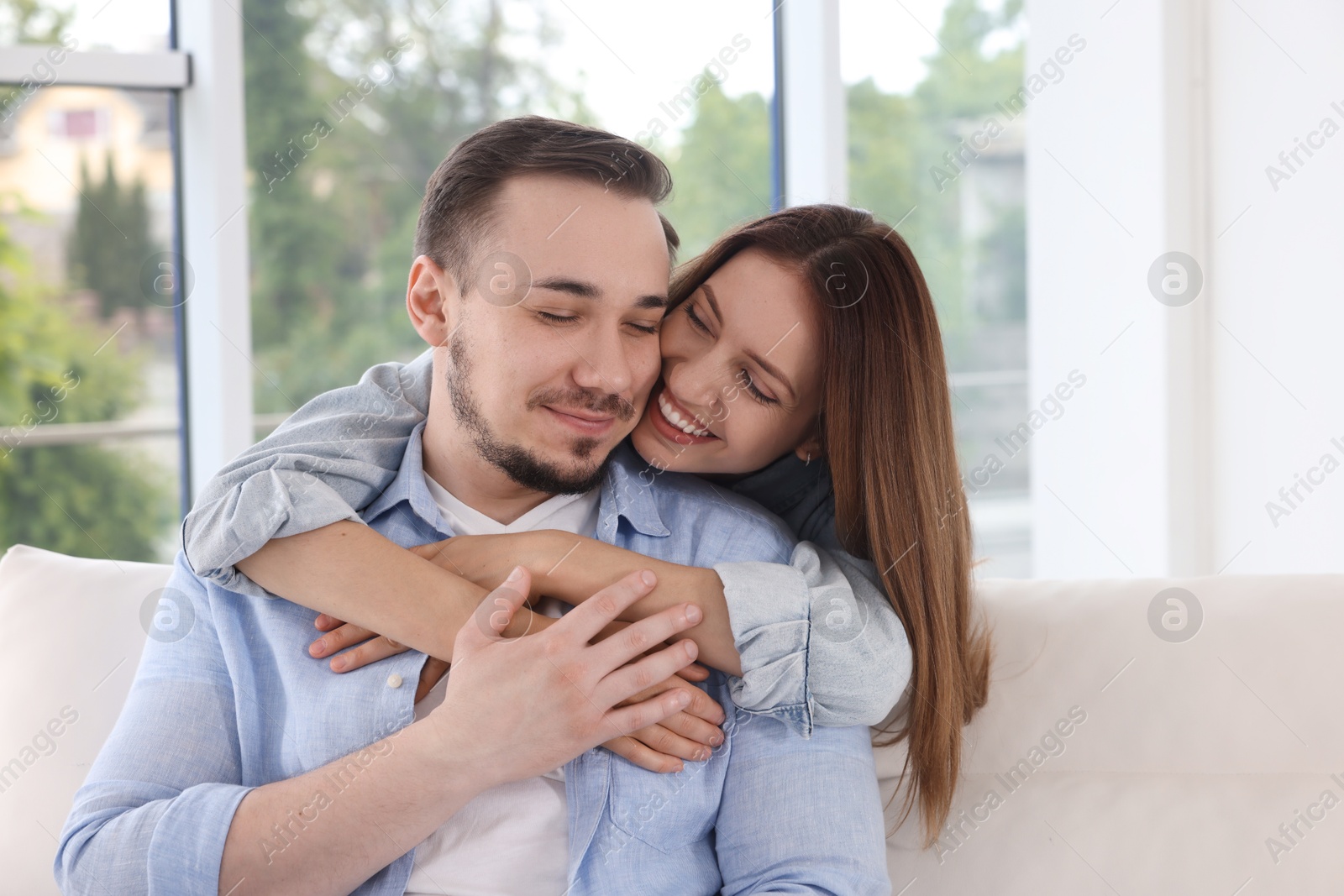 Photo of Happy woman hugging her boyfriend at home