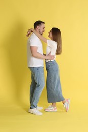 Photo of Happy couple hugging on yellow background. Strong relationship