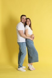 Photo of Happy couple hugging on yellow background. Strong relationship