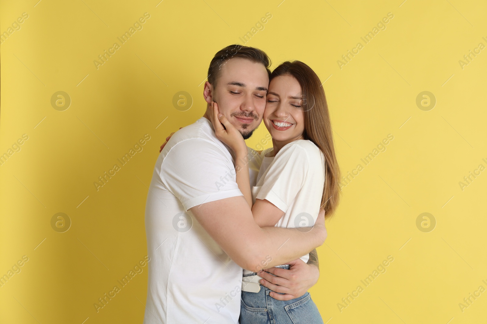 Photo of Happy couple hugging on yellow background. Strong relationship