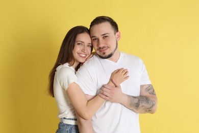 Portrait of cute couple on yellow background