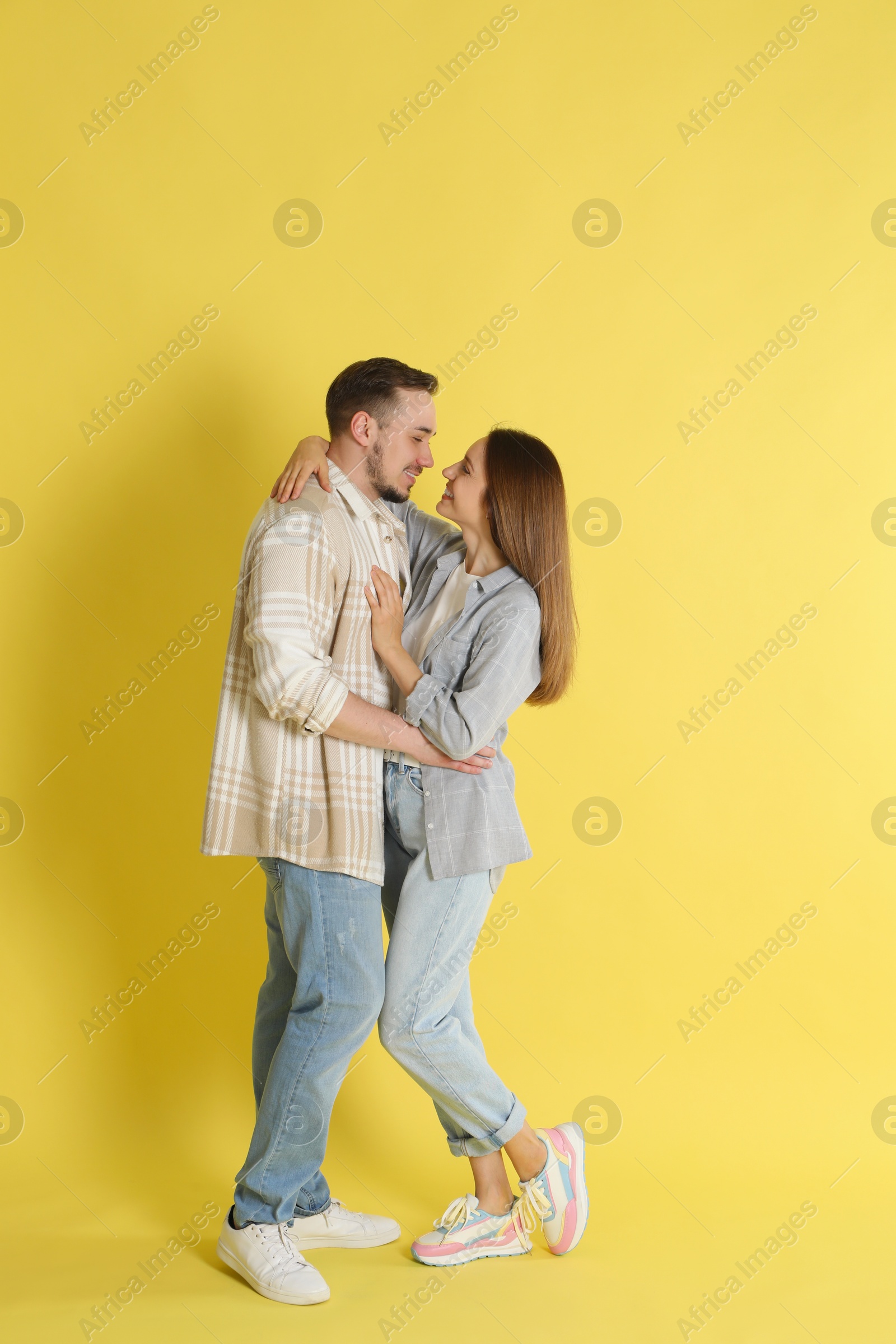 Photo of Happy couple hugging on yellow background. Strong relationship