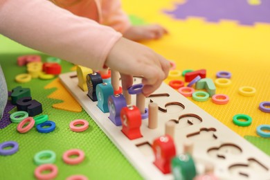 Little girl playing with game Fishing for Numbers on puzzle mat, closeup. Kindergarten activities for learning mathematics