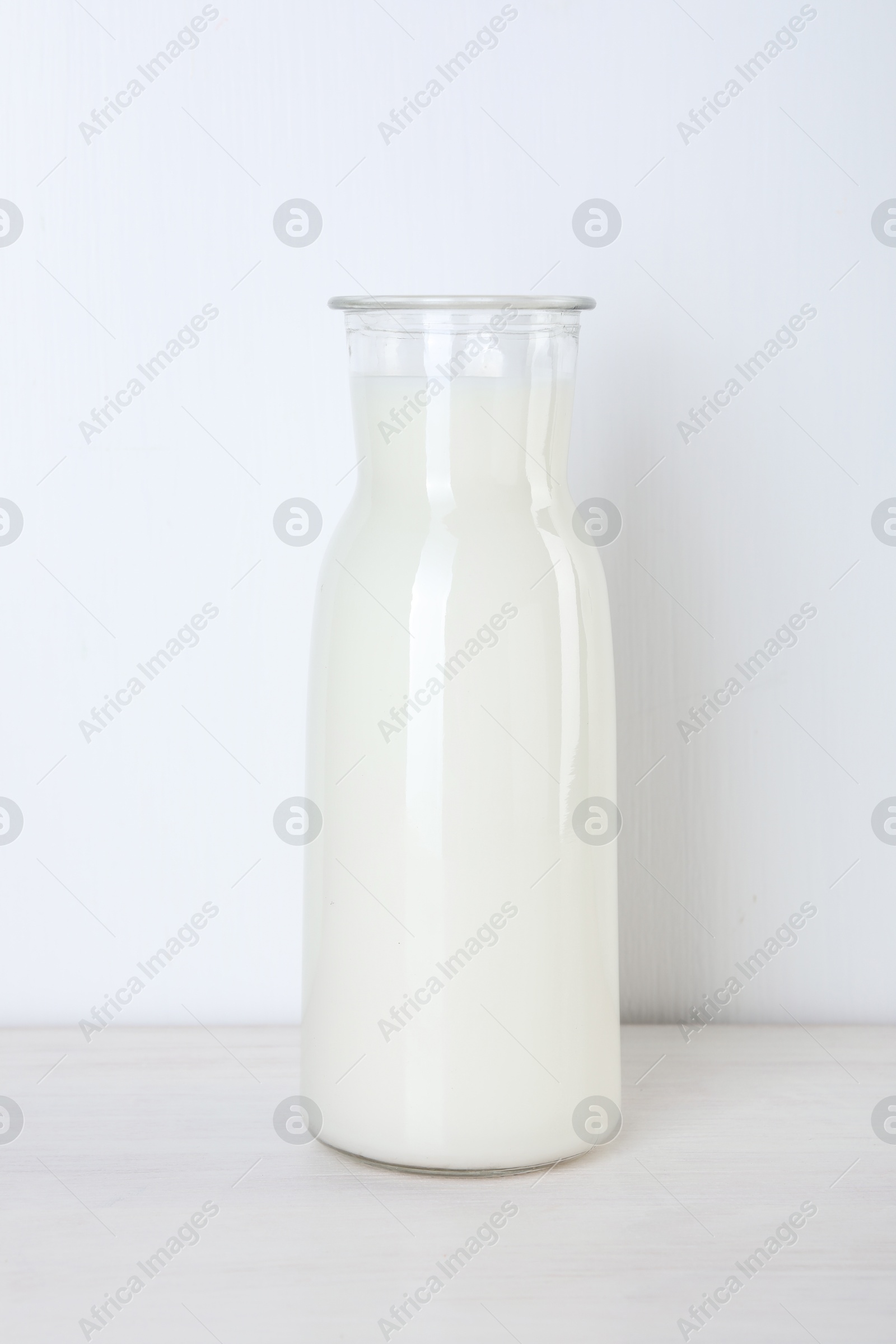Photo of Glass carafe of fresh milk on wooden table