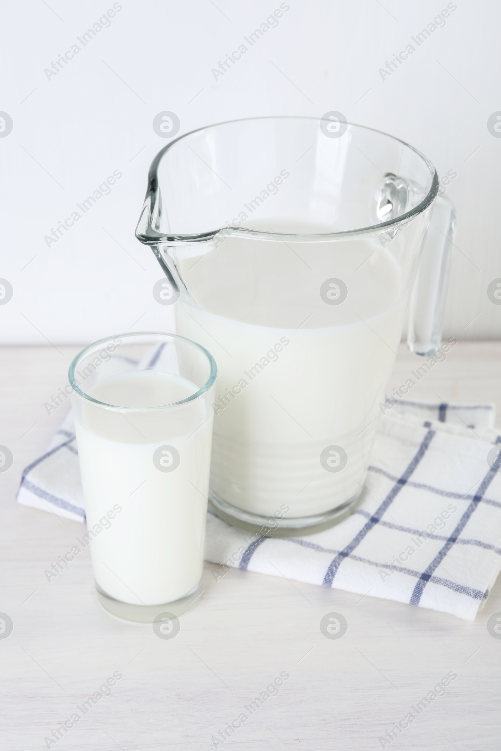 Photo of Jug and glass of fresh milk on wooden table