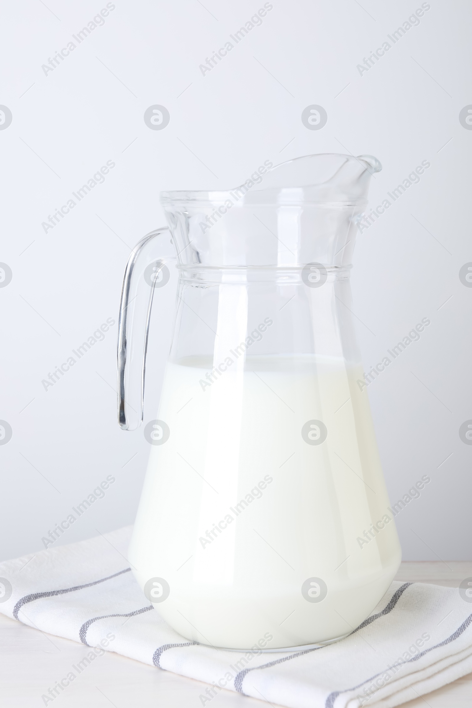 Photo of Glass jug of fresh milk on table