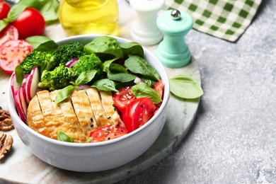 Photo of Healthy meal. Delicious chicken, vegetables and spinach served on light grey table, space for text