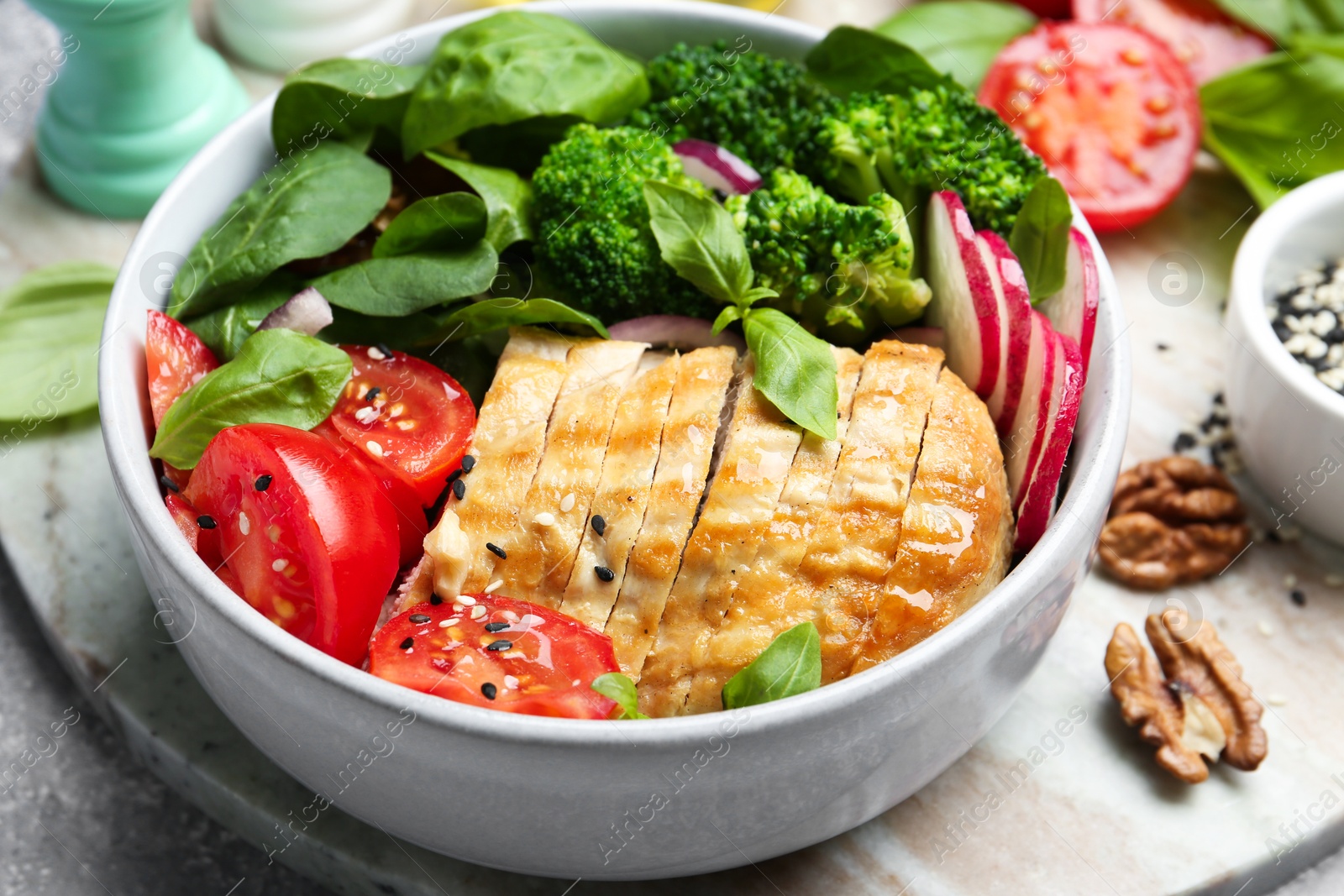 Photo of Healthy meal. Delicious chicken, vegetables and spinach in bowl on table, closeup