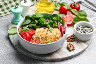 Healthy meal. Delicious chicken, vegetables and spinach served on light grey table