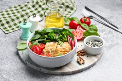 Healthy meal. Delicious chicken, vegetables and spinach served on light grey table