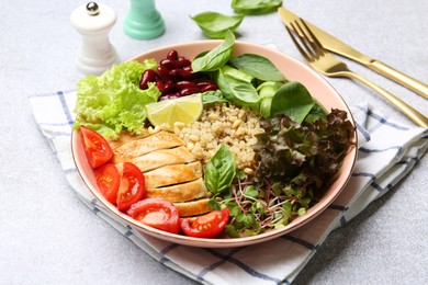 Healthy meal. Tasty vegetables, quinoa and chicken breast in bowl on white table