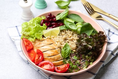 Photo of Healthy meal. Tasty vegetables, quinoa and chicken breast in bowl on white table