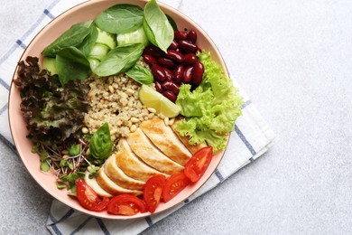 Photo of Healthy meal. Tasty vegetables, quinoa and chicken breast in bowl on white table, top view. Space for text