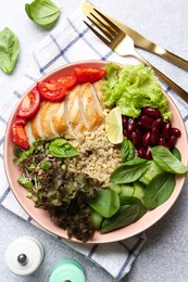 Photo of Healthy meal. Tasty vegetables, quinoa and chicken breast in bowl on white table, flat lay