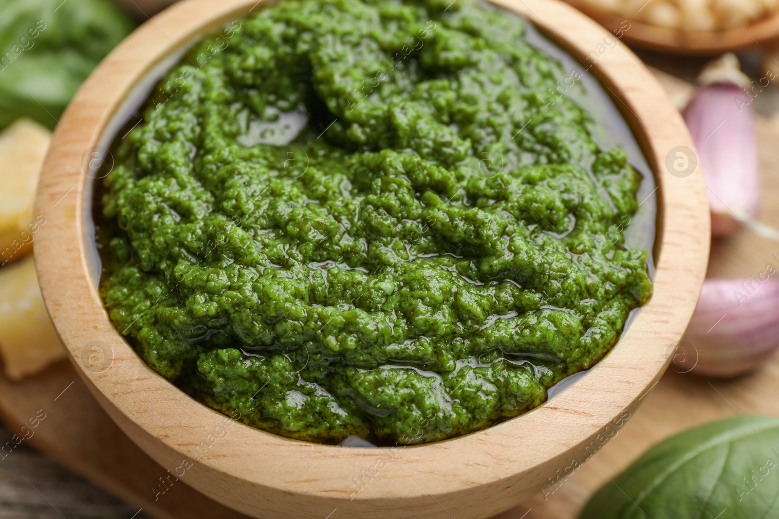 Photo of Tasty pesto sauce in bowl on table, closeup