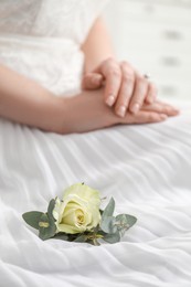 Photo of Bride with boutonniere for her groom on dress, closeup