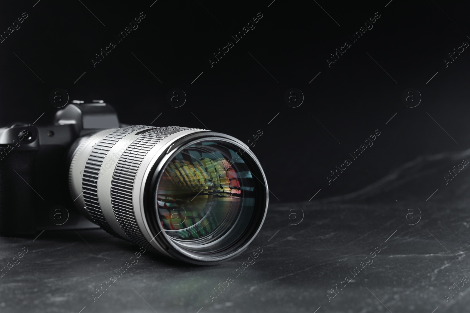 Photo of Modern photo camera on black table, space for text