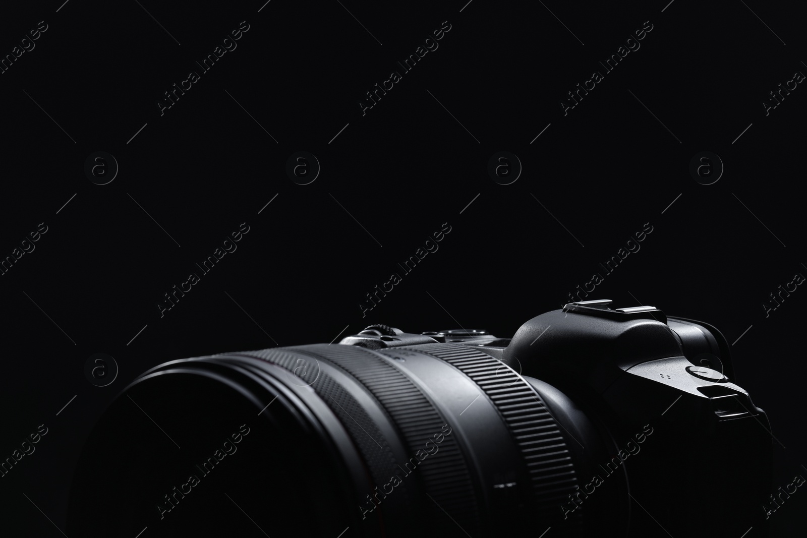 Photo of Modern photo camera on black background, closeup. Space for text