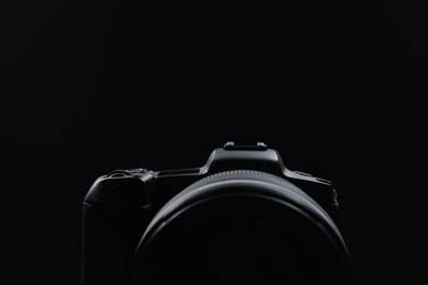 Modern photo camera on black background, closeup. Space for text