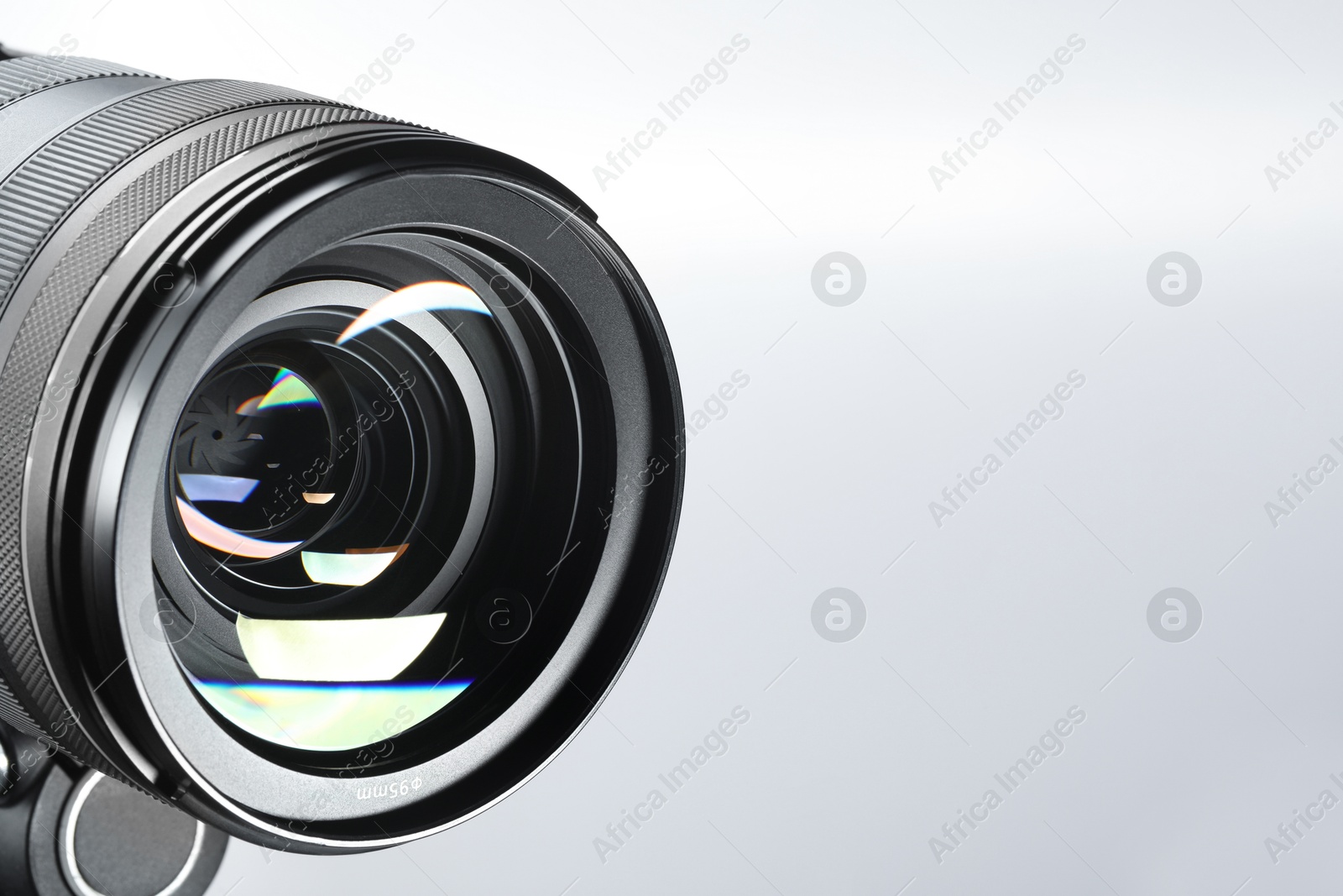 Photo of Modern camera lens on white background, closeup. Space for text