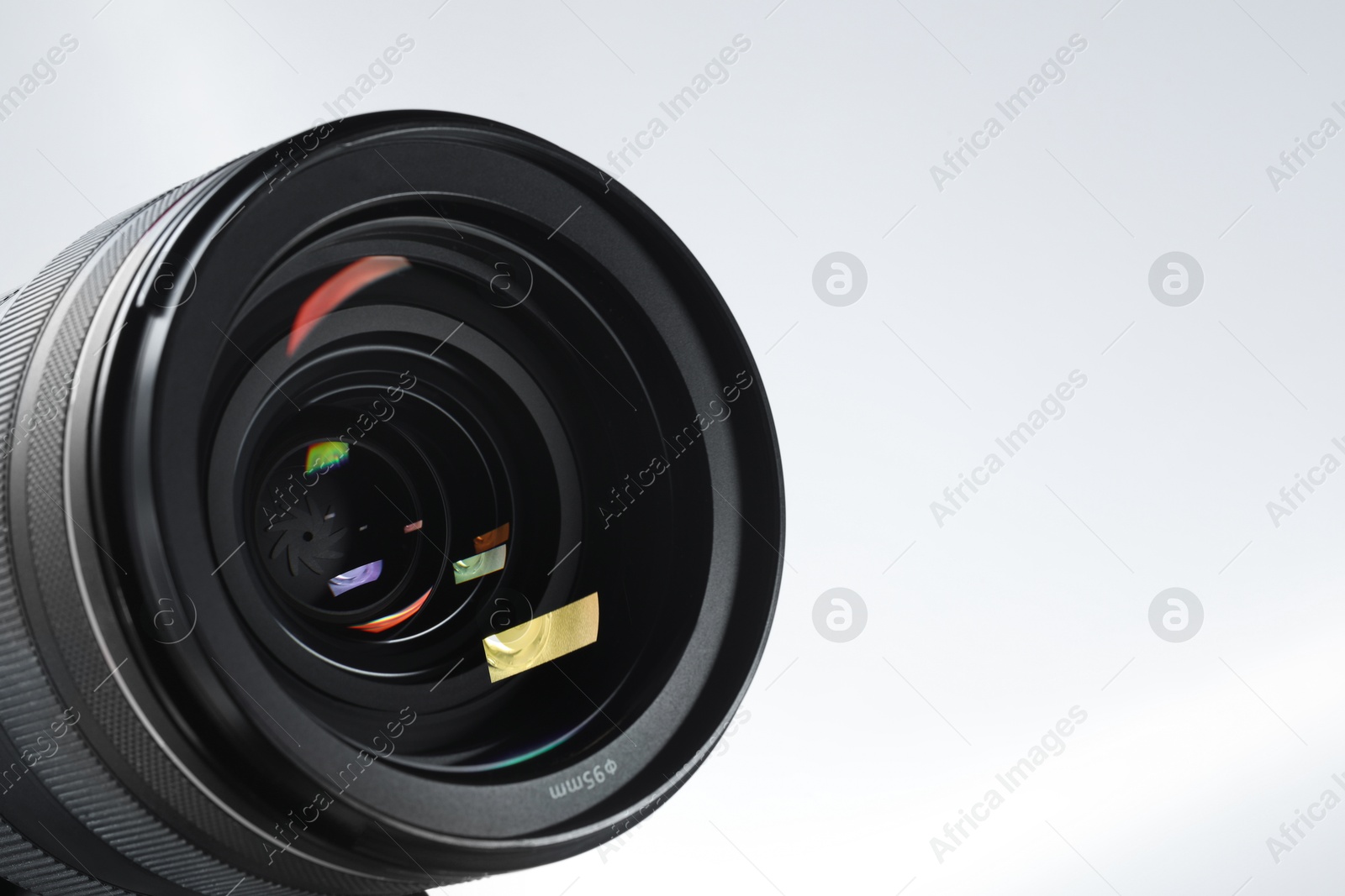 Photo of Modern camera lens on white background, closeup. Space for text