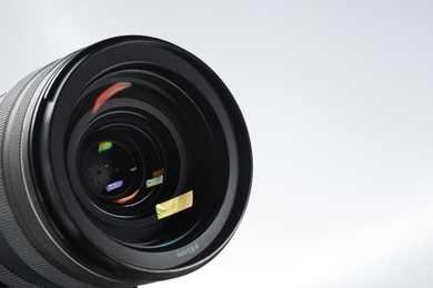 Modern camera lens on white background, closeup. Space for text