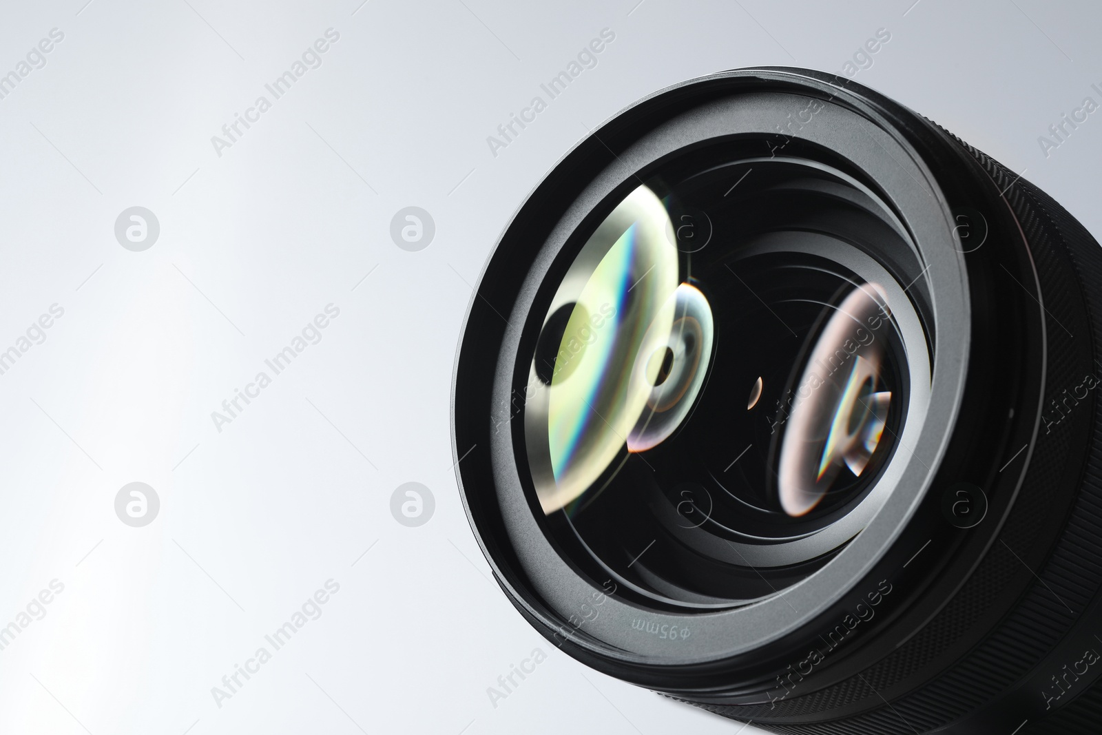 Photo of Modern camera lens on white background, closeup. Space for text