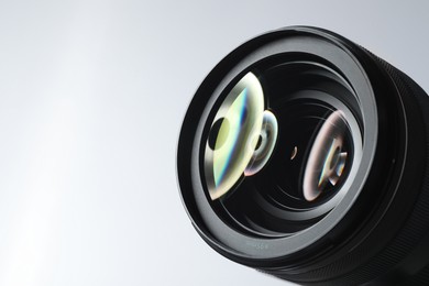 Modern camera lens on white background, closeup. Space for text