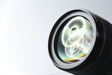 Modern camera lens on white background, closeup. Space for text