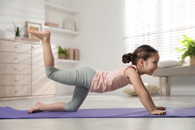 Cute little girl doing exercise at home