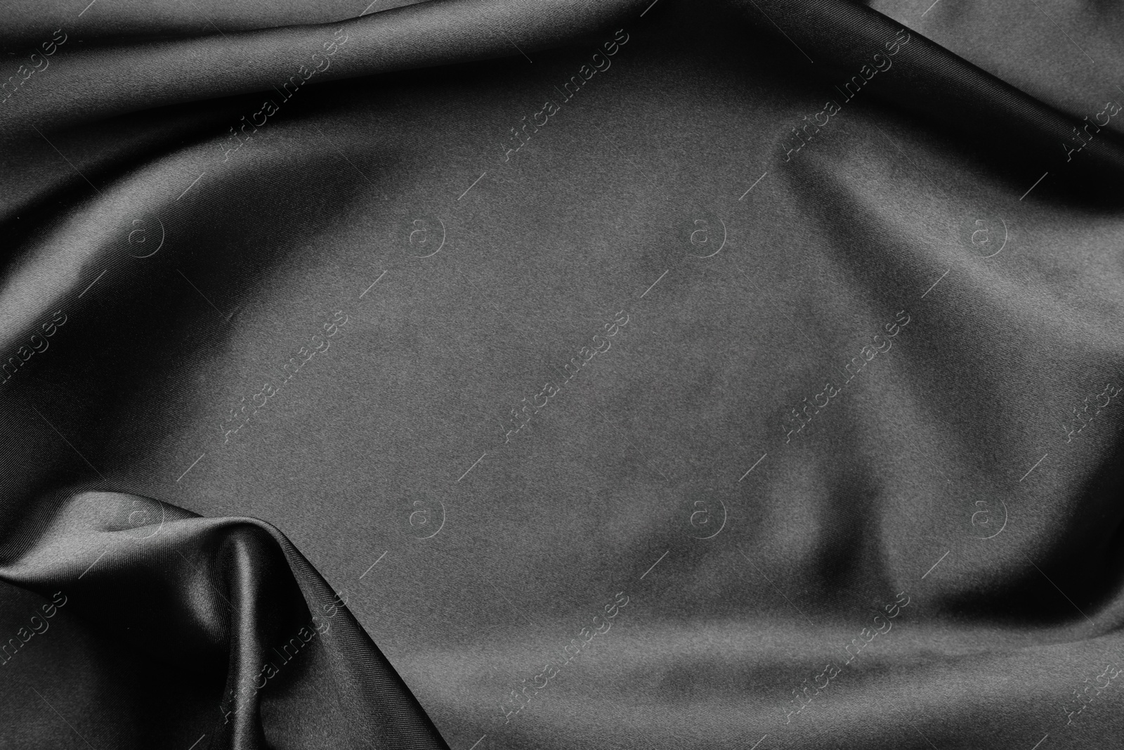 Photo of Crumpled black silk fabric as background, top view. Space for text