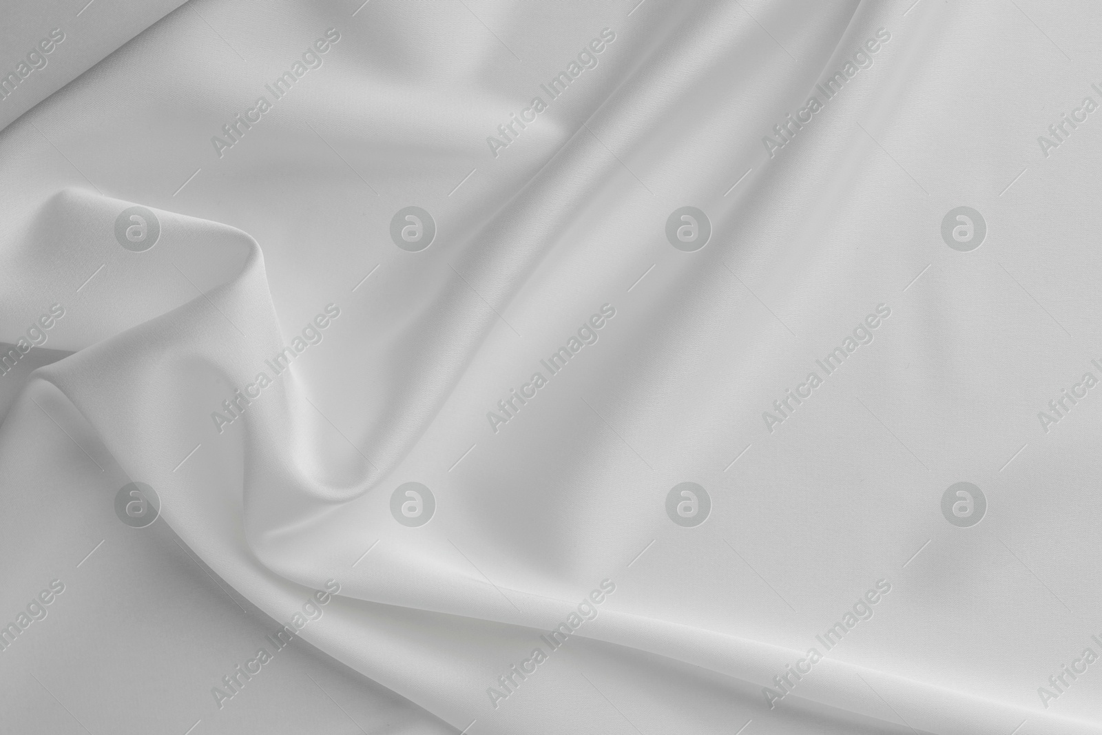 Photo of Texture of crumpled white silk fabric as background, top view