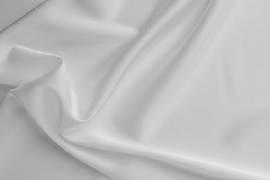 Photo of Texture of crumpled white silk fabric as background, top view