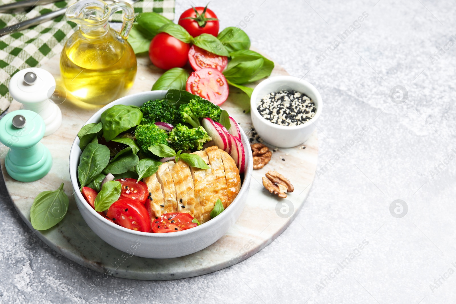 Photo of Healthy meal. Delicious chicken, vegetables and spinach served on light grey table, space for text