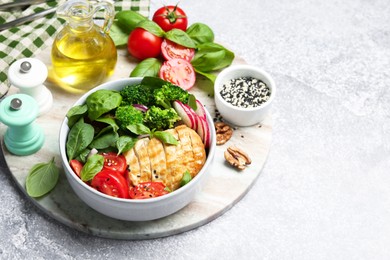 Photo of Healthy meal. Delicious chicken, vegetables and spinach served on light grey table, space for text