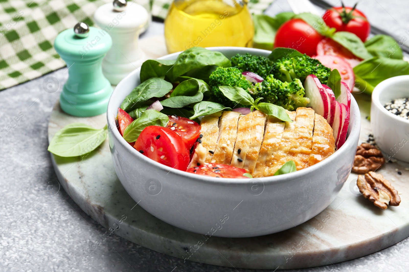 Photo of Healthy meal. Delicious chicken, vegetables and spinach served on light grey table, closeup