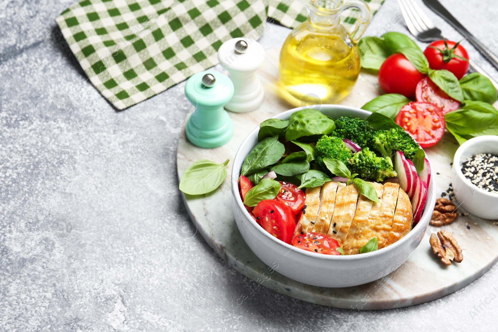 Photo of Healthy meal. Delicious chicken, vegetables and spinach served on light grey table, space for text