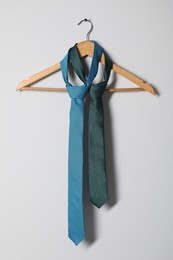 Photo of Hanger with different stylish neckties on light wall